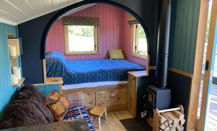 Handbuilt cabin with wood burning stove, ensuite bathroom and outdoor bath, super comfy king size bed, cozy sofa, sheepskin rugs and Welsh woolen blan